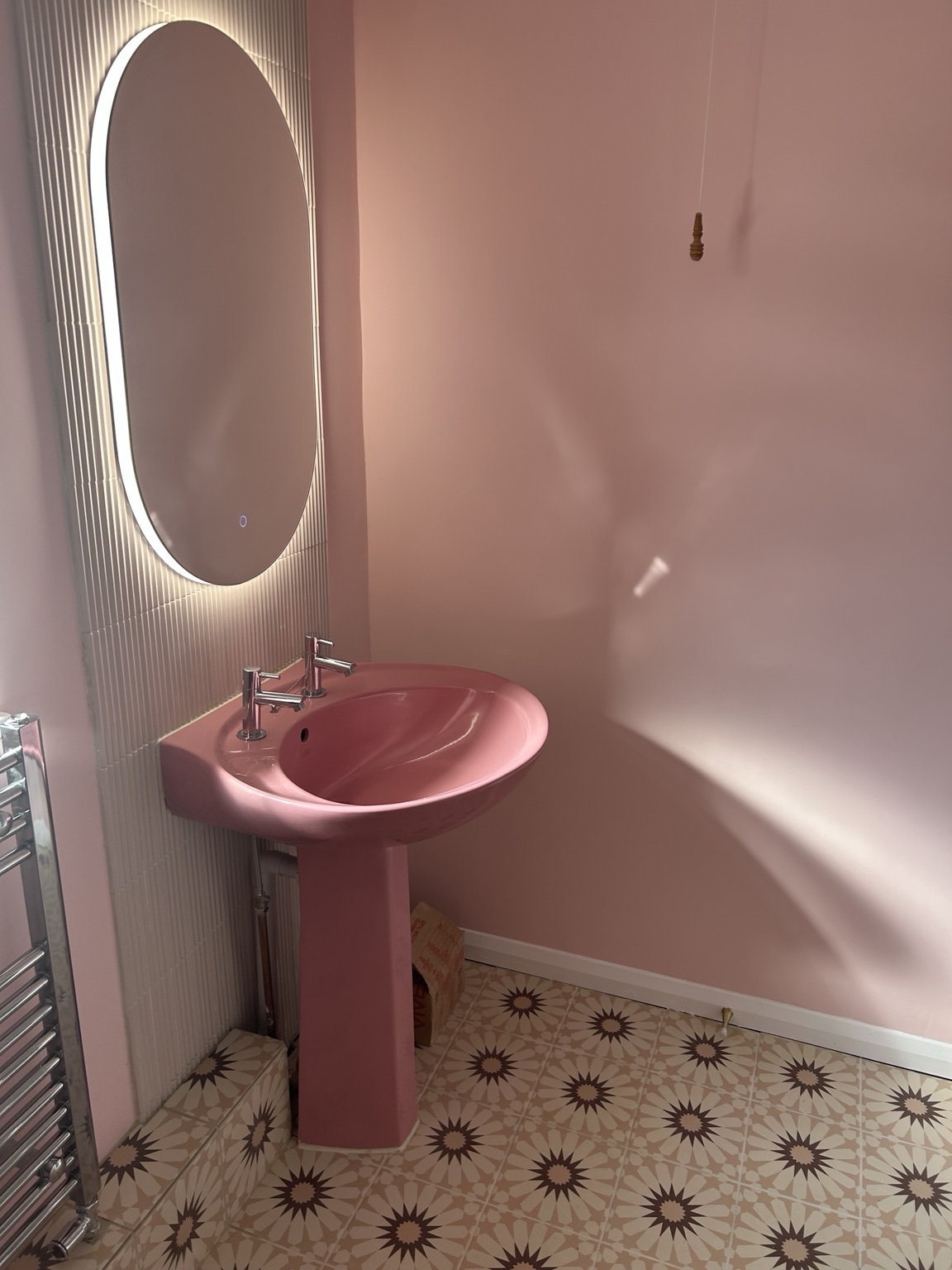 Walls prepared and decorated, finished around the retained pink basin